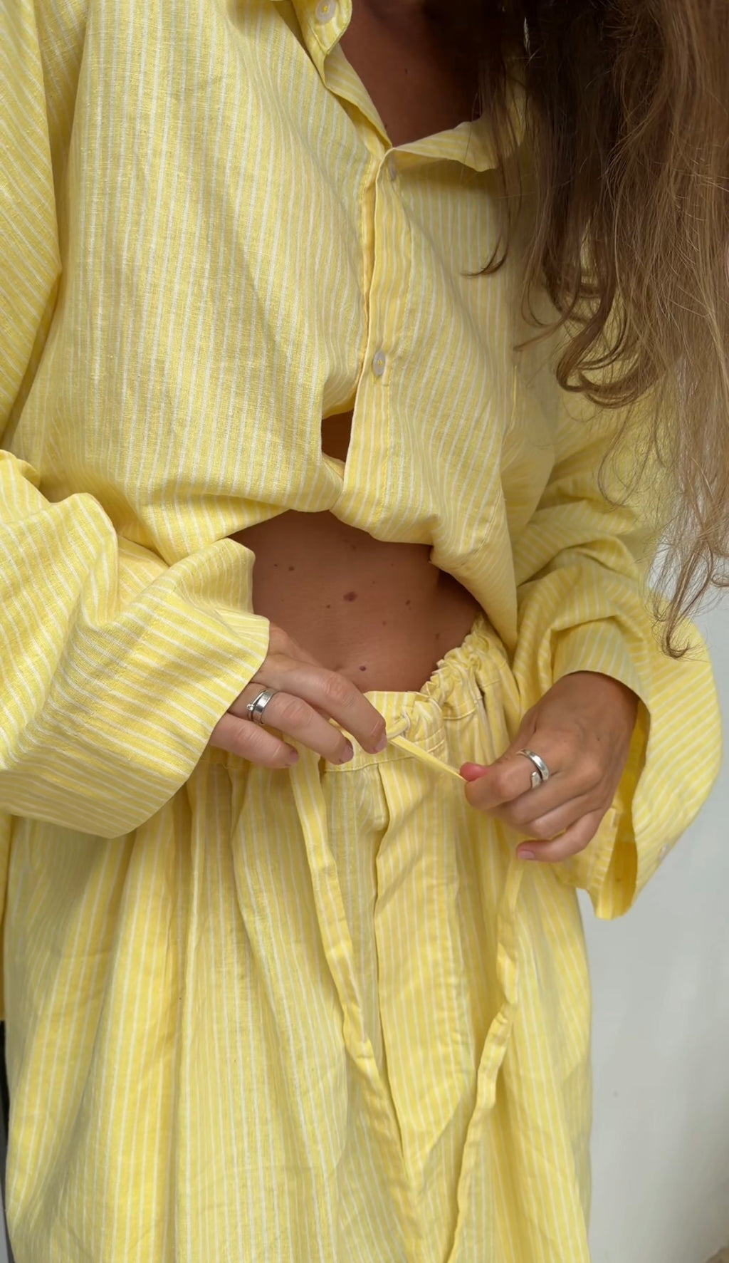 Person wearing a yellow outfit with a plain background